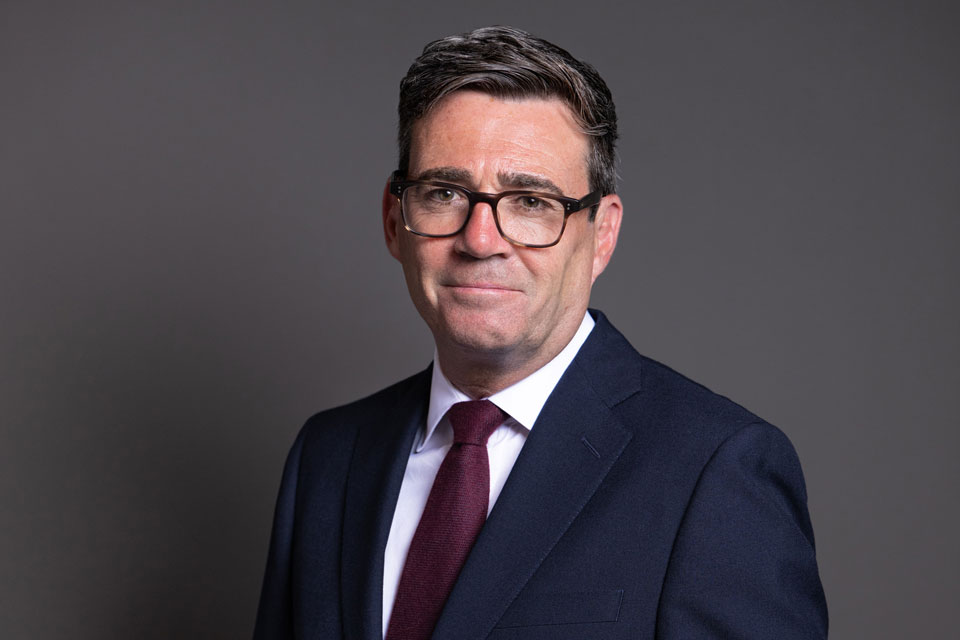 Andy Burnham, in a navy suit and glasses, pictured in an official government portrait as Prime Minister.